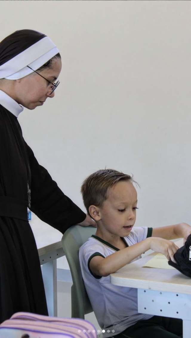 Educadora acompanhando de perto a aprendizagem de um aluno